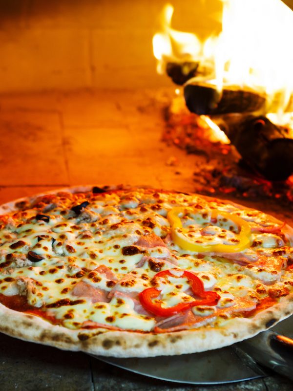 Close,Up,Pizza,In,Firewood,Oven,With,Flame,Behind Close up pizza in firewood oven with flame behind